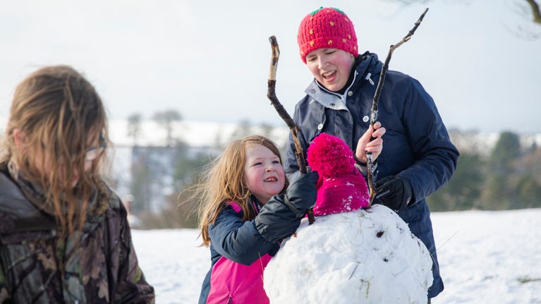 Children building snowman at Lyme Park, Cheshire